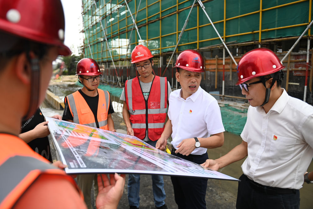 在浙江省宁波市奉化区萧王庙街道滕头村，二十大代表、滕头村党委书记、村委会主任傅平均（右二）在村党群服务中心大楼建设工地察看施工进展（2022年9月16日摄）。